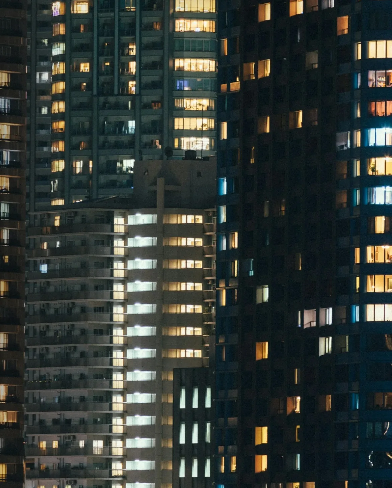Torres residenciais à noite, com janelas acesas